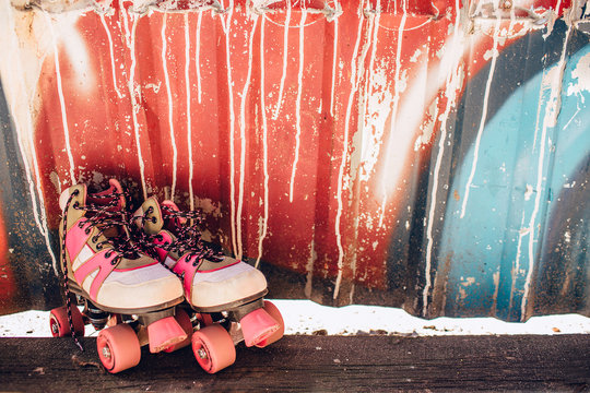 Cute and nice rollers are standing at the colorful wall. There are pink, white, blue and black colors on the wall.