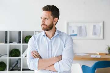 Handsome businessman standing with arms folded