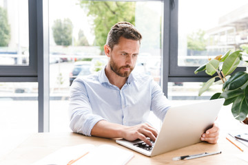 Concentrated businessman working on laptop computer