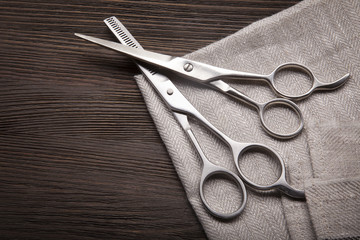 Hairdressing scissors on a black wood background.