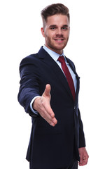 businessman welcomes you with a handshake in his company