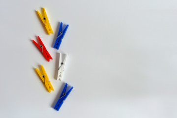 Multi-colored clothespins on a white background. Funny colored clothespins. Designer background