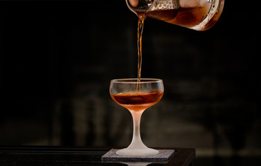 Pouring cocktail into coupe - obrazy, fototapety, plakaty