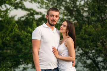 Dating in park. Love couple standing together on grass near the lake. Romance and love