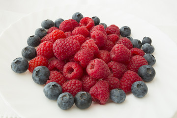raspberry and blueberries on white background