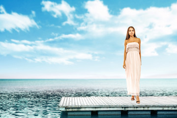 Summer time and slim woman on pier. Sea landscape with blue sky. 