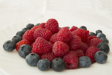 raspberry and blueberries on white background