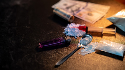 Drug injection syringe on heroin powder. Spoon with cigarette lighter for heroin cooking and money...