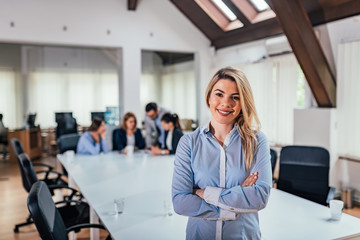 Obraz premium Portrait of successful female entrepreneur, colleagues in the background.