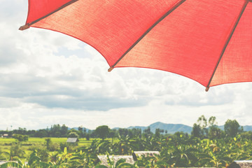 Red umbrella under nimbus sky at house terrece.