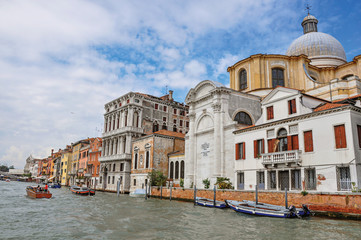Obraz na płótnie Canvas View of ancient buildings and church facing the Grand Canal, at the city center of Venice, the historic and amazing marine city. Located in Veneto region, northern Italy