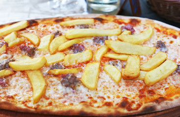 traditional italian pizza with potato fries, sausages, cheese and tomato sauce - famous italian food 