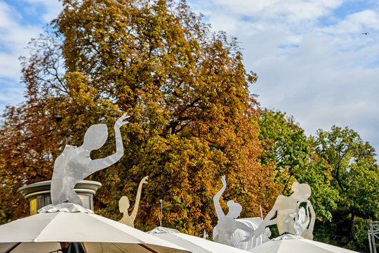 Figures of ballerinas on street umbrellas cafe