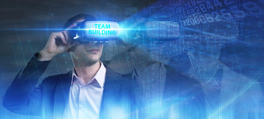 Business, Technology, Internet and network concept. Young businessman working in virtual reality glasses sees the inscription: Team building
