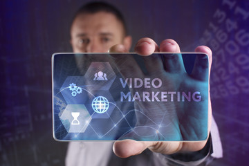 The concept of business, technology, the Internet and the network. A young entrepreneur working on a virtual screen of the future and sees the inscription: Video marketing