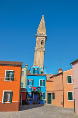 Obraz premium Overview of colorful buildings and leaning bell tower in a blue sunny day at Burano, a gracious little town full of canals, near Venice. Veneto region, northern Italy