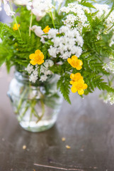 Still life with bouquet wild flowers and grass on old wooden table
