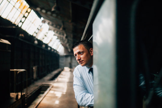 Young Train Driver Looking Outside From The Cab Of A Diesel Locomotive