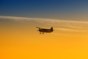 Fototapeta na wymiar Airplane flying in vibrant sunset