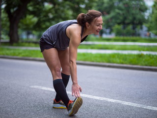 female runner warming up and stretching before morning training