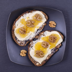 Sandwich of unleavened bread with butter, cheese, honey and walnuts , close up