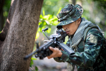 Squad of soldiers patroling across the deep forest area.
