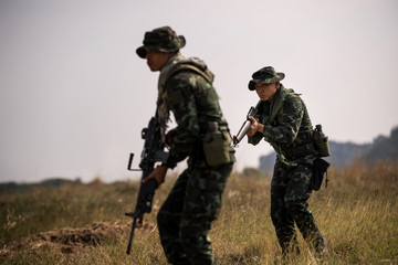 Squad of soldiers patrolling across the deep forest area.