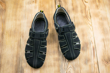 men's sports black suede sandals on a wooden background