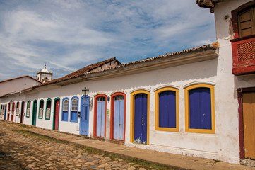 Overview of cobblestone street with old houses under blue cloudy sky in Paraty, an amazing and...