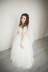 Fototapeta premium Luxury bride in white dress posing while preparing for the wedding ceremony