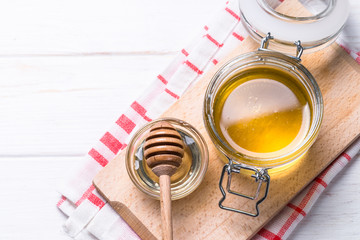 Honey  in a jar with dipper on white