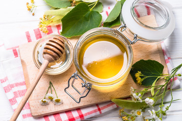 Honey  in a jar with dipper on white