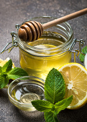Honey in a jar with lemon and mint.
