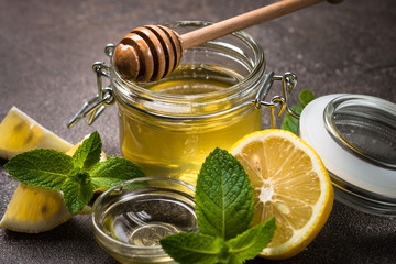 Honey in a jar with lemon and mint.