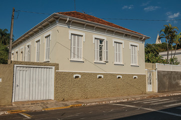Working-class old house with garage door in an empty street on a sunny day at São Manuel. A cute little town in the countryside of São Paulo State, southeast Brazil