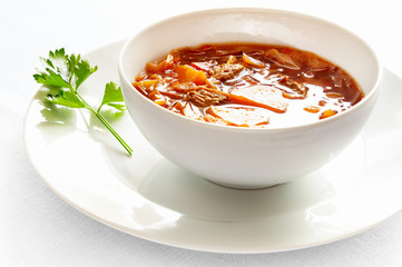beetroot soup with veal, cabbage, potato, carrot, onion, garlic, and herbs decorated with lovage