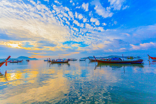 sweet sunrise above fishing boats in Rawai sea during high tide