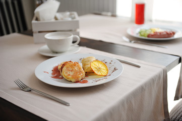 Served breakfast in the restaurant. Cottage cheese pancakes with orange ringlets and coffee