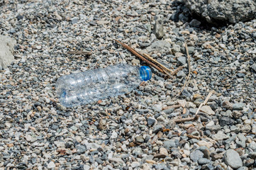 Empty plastic garbage dumped on pebble stones