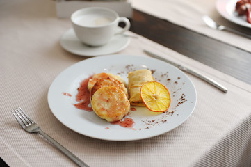 Served breakfast in the restaurant. Cottage cheese pancakes with orange ringlets and coffee