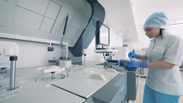 Laboratory worker puts samples into a rack. Woman Scientist Working in Laboratory. 4K.