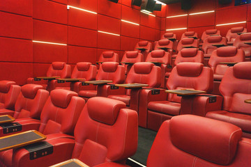 Movie theater empty auditorium with red leather comfortable chair