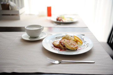 Served breakfast in the restaurant. Cottage cheese pancakes with orange ringlets and coffee