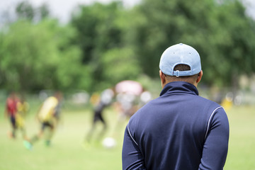 Football or socker coach observing kid football match.Healthy sport concept.