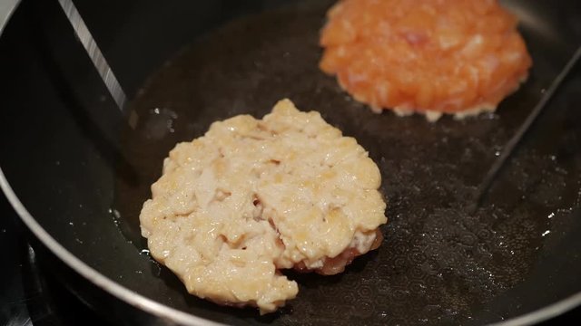 chef hand grill salmon mince burger on a pan.