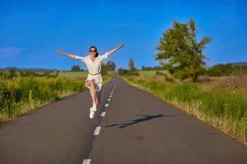 Fototapeta premium Beautiful girl dressed in white shirt and running along the way