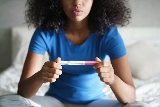 Sad Young Woman With Pregnancy Test At Home