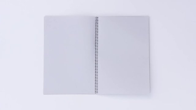 Turning page binder book by wind on a white background