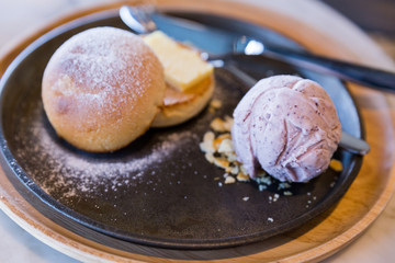Bread and butter topping with icing sugar served with a scoop of taro ice cream.