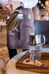 Vietnamese drip black coffee method while pouring hot water.